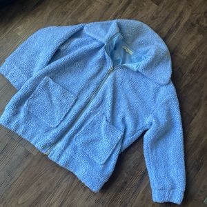 Baby blue zip up Sherpa jacket with front pocket details.